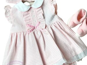 Round collar baby dress with checkered design and ruffles. Three little buttons on the chest and a tiny pink bow.  Paired with knicker and bonnet. 67%POLYESTER 33%COTTON-WOVEN Made in Spain Size: 3M