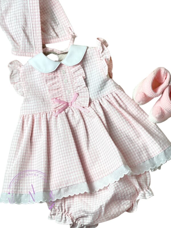 Round collar baby dress with checkered design and ruffles. Three little buttons on the chest and a tiny pink bow.  Paired with knicker and bonnet. 67%POLYESTER 33%COTTON-WOVEN Made in Spain Size: 3M
