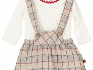 Baby girls cream colored long sleeve top with a ruffled collar with a red zig zag trim paired with a bib style suspender with red, gray , taupe and dark gray checkered print dress on a white background.
