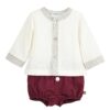 Infant boys cream colored long sleeved top with a maroon floral patterned trim on the neck, wrists and buttoned down front with maroon colored jam pants with button on a white background.