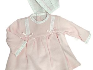 Long sleeved pink dress with polka dot trim on wrists neckline, bloomers and bonnet. lace trim with pink satin ribbons and bows on a white back ground