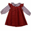 Rich red corduroy dress with a ruffled collar and a long sleeved checkered blouse with a ruffled collar on a white background