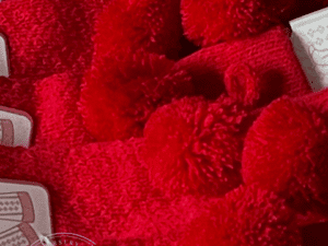 a collage of bright red knit baby high socks with pom pom decoration.