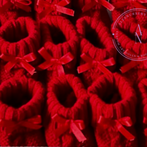 A collage of red cable knit baby booties with satin bows.