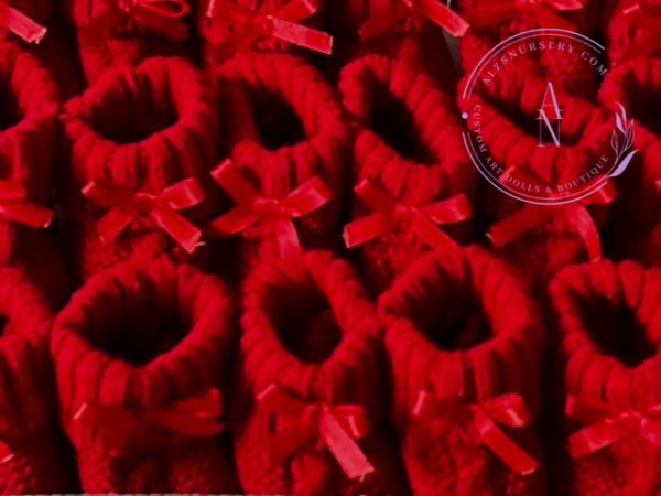 A collage of red cable knit baby booties with satin bows.