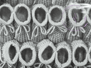 A collage of gray knitted newborn baby booties.