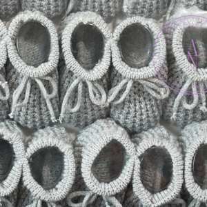 A collage of gray knitted newborn baby booties.