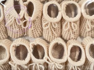 A collage of tan colored knitted newborn baby booties.