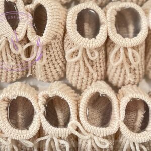 A collage of tan colored knitted newborn baby booties.