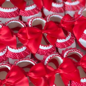 A collage of spanish styled Red and white ruffled soft baby shoes with large satin bows