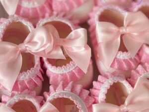 A collage of spanish styled pink ruffled soft baby shoes with large satin bows