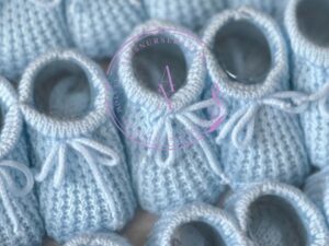 Baby blue colored knitted newborn baby booties made in Spain, sold by Alz's Baby Boutique