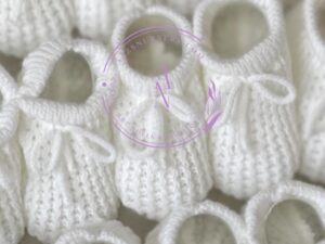 Soft fresh white colored knitted newborn baby booties made in Spain, sold by Alz's Baby Boutique