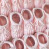 Soft pink colored knitted newborn baby booties made in Spain, sold by Alz's Baby Boutique