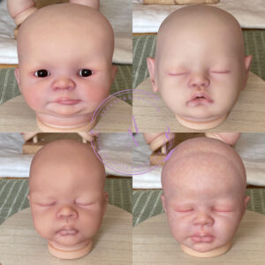 Four reborn doll heads in the progress of being painted. Awake and sleeping being displayed on a wooden turntable.