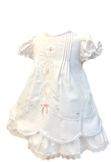 This baby heirloom dress is so incredibly sweet! Having the most beautiful white and pink delicate trim with scalloped  lace border throughout the entire dress with puffed gathered and ruffled short sleeves. This beautiful gown has the most intricate and dainty embroidered flowers and lace border with rows of pin tucks and sewn in seed pearls, a beautiful bow on the back and fully lined. This dress is absolutely priceless and will be a treasure for generations to come. 65% polyester 35% cotton Made in Columbia Size- Newborn Sold by Alz's baby Boutique