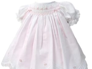 This is an absolutely precious white with pink scalloped dress with the daintiest embroidered white pink flowers over the smocking. This adorable baby dress has gathered puffed and ruffled short sleeves. Trimmed with the sweetest white lace scallop border, pink and white satin bow details. The most precious and elegant rows of pin tucks make this dress simply stunning. 65% polyester 35% cotton Made in Columbia Size- Preemie Sold by Alz's Baby Boutique