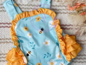 This adorable baby romper has the cutest yellow layered ruffles on the rump and around the face of the body. The straps and the rest of the body has a sweet bumble bee patterned print with white and yellow flowers. Size 6m, 12m  Sold by Alz's Baby Boutique