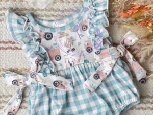 This adorable baby romper has a beautiful light blue and white checkered print with ruffled trim. The front has the cutest print with trucks and construction theme. Finishing off this sweet look with double bows. Size 6m, 12m  Sold by Alz's Baby Boutique