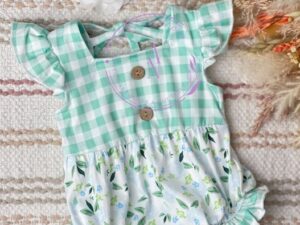 This sweet summer baby romper has a beautiful mint green and white plaid printed top and ruffled capped short sleeves. With the leggs having the print on the ruffles. The bottom half is printed with a dainty floral print with shades of green, baby blue and white. 95% Polyester  5% Spandex  Size 6m, 12m Sold by Alz's baby Boutique