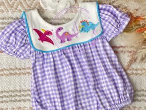 How adorable is this baby bubble romper with its purple and white checkered print. A white bib having the cutest embroidered dinosaurs in colors of magenta, light purple and blue. the gathered short sleeves make this outfit perfect for summer. Size 3m, 6m, 12m Sold by Alz's Baby Boutique
