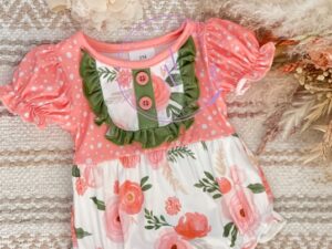 This adorable summer baby romper has the most cheerful printed material. A coral and white polka dots print on the top and gathered ruffled capped short sleeves and the bottom having a white, coral, green and soft pink floral print with ruffled trimmed legs. Finishing off the details with a sweet sap green ruffle and buttons. 95% Polyester  5%Spandex  Size 6m, 12m Sold by Alz's Baby Boutique