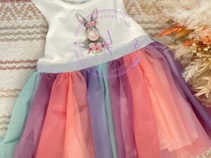This adorable sleeveless Easter tutu dress has layers of colorful ruffles in purples, pinks, green and peach. Trimmed with a pretty sash and the cutest bunny printed on the chest. Your little one will surely love wearing this dress. Size 12m Sold by Alz's Baby Boutique