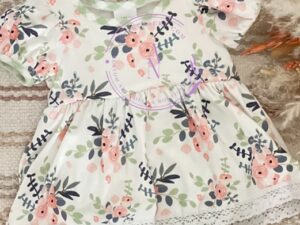 This one piece baby girls romper dress has a beautiful floral print in shades of green, pink, and gray. Complemented with a sage green and white checkered print trim and under layer with scalloped lace trim and puffed short sleeves. Size 6m Sold by Alz's Baby Boutique